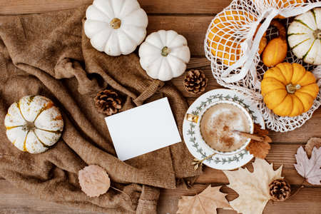 Autumn Leaves Composition with White Paper Sheet on Wooden Background, Top View of Set for Copy Space. Beautiful Autumn Foliage with Blank White Note Template for Greeting Card, Sale, Advertisingの写真素材