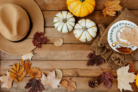 Flat lay Autumn still life with a coffee cup and pumpkins on wooden background. Stylish autumn composition.の写真素材