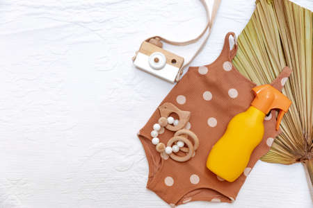 Flat lay baby swimsuit and Sunscreen .Plastic bottle of sun protection. Cream for kids.の写真素材