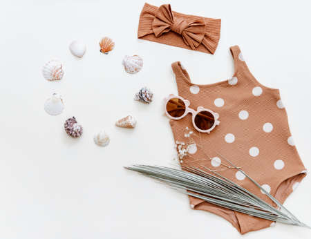 Retro swimsuit with baby accessories. Kids sunglasses, and empty blank card. Summer Fashion newborn, Holiday concept. Flat lay, top viewの写真素材