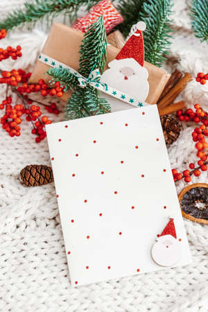 Christmas background with gift card and Christmas decorations on cozy knitted background. Flat lay, top view and copy space for textの写真素材