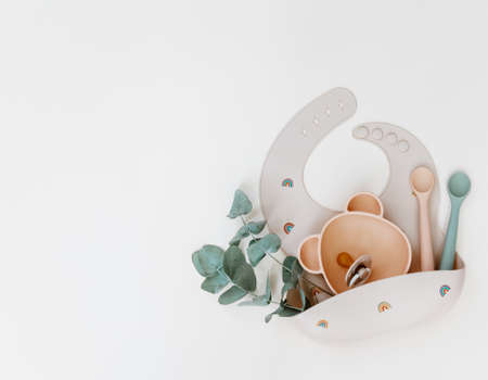 Baby feeding accessories. Silicone bib, Baby set dishes. Flat lay, top view, copy space.の写真素材