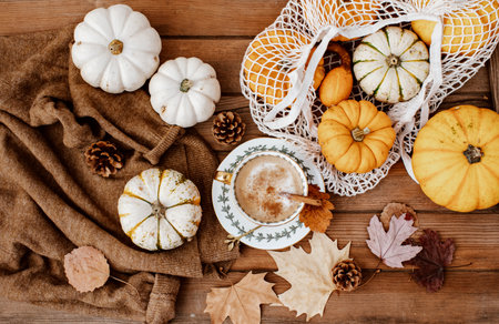Flat lay Autumn still life with a coffee cup and pumpkins on wooden background. Stylish autumn composition.の写真素材