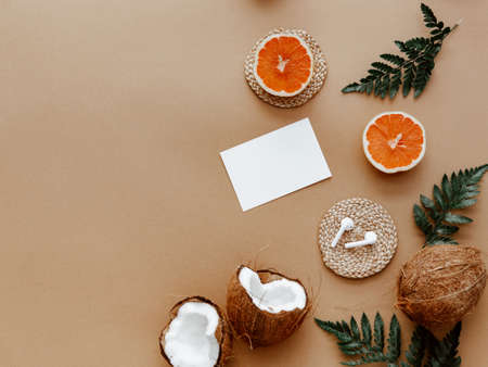 Blank paper card and a cup of coffee. Minimal concept with oranges and green leaves. Mock up or...