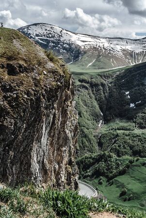 mountain road among the large snow-capped mountains in Georgia Gudauri, view from a high mountain,beautiful mountains, hills, georgia, on top of a mountainの写真素材
