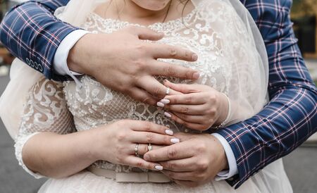 wedding rings on the hands of the newlyweds