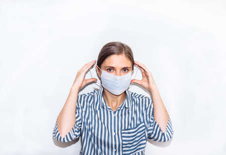 young woman in a blue striped shirt in a medical mask. remedy for coronavirus, pandemic, covid 19, pneumonia.の写真素材
