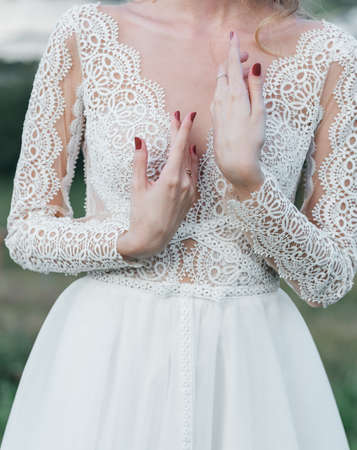 brides hand with an elegant wedding ring with white gold diamonds on a bouquet of their peoniesの写真素材