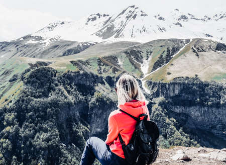 young woman teenager stands with her back with a backpack on the observation deck overlooking the...