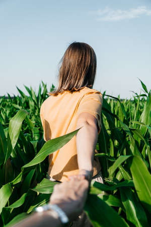 young woman in a corn field in a yellow t-shirt with a place under the text with short hair
