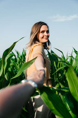 young woman in a corn field in a yellow t-shirt with a place under the text with short hairの写真素材