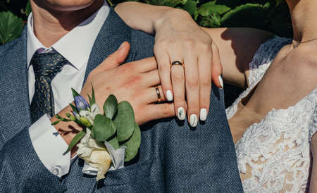 hands of young people with wedding wedding rings. wedding day details. calla flowers. spouses...