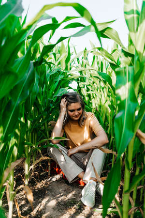 young woman in a corn field in a yellow t-shirt with a place under the text with short hair