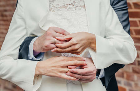 hands of young people with wedding wedding rings. wedding day details. calla flowers. spouses newlyweds groom and brideの写真素材