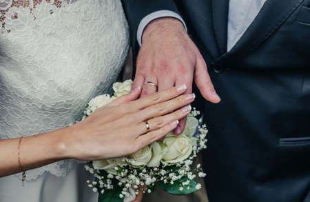 hands of young people with wedding wedding rings. wedding day details. calla flowers. spouses newlyweds groom and brideの写真素材