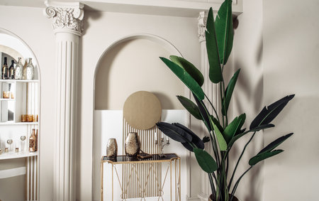 designer apartment interior shelf cabinet with souvenirs bottles figurines bar mirror table chair glass glasses.の写真素材