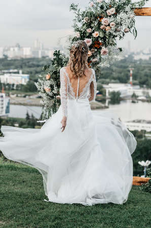 lovely beautiful young slender bride in an airy elegant white wedding dress with lace smile gentle portraitの写真素材