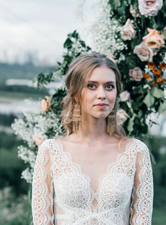 lovely beautiful young slender bride in an airy elegant white wedding dress with lace smile gentle portraitの写真素材