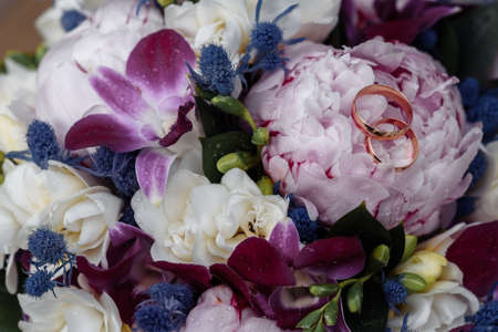 hands of young people with wedding wedding rings. wedding day details. calla flowers. spouses...