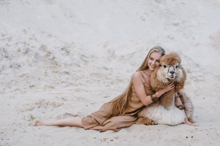 young slender beautiful slim sexy woman on white sand on the beach with long blond hair bracelets accessories on armsの写真素材