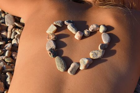 Natural hot stones on the back. Sea stone treatment. Stone therapy.