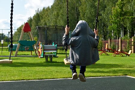 boy swinging on a swingの写真素材