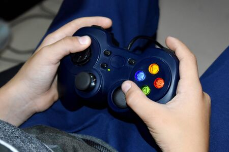 A boy holds a computer joystick.