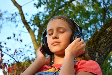 The music lover of  girl. Enjoyment of solitude and music. A teenager alone listens  music in large...