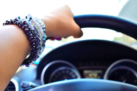 Female high-speed driving. Businesswoman in a car. Female hand holds the steering wheel.の写真素材