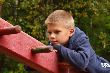 A boy on the playground goes in for sports. Training of children in the fresh air. Active children's...