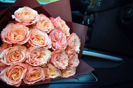 Delicate bouquet of peony roses. Home flower delivery. Beautiful roses in a car.の写真素材