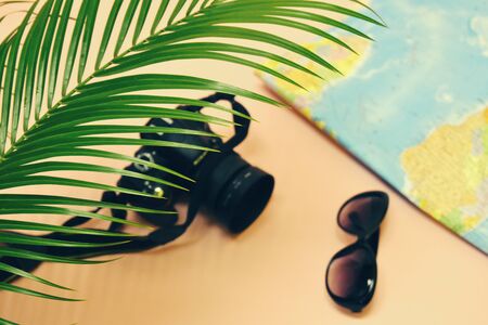 Travel and vacation concept in the tropics. Taking photos in nature. Camera, glasses and world map.の写真素材