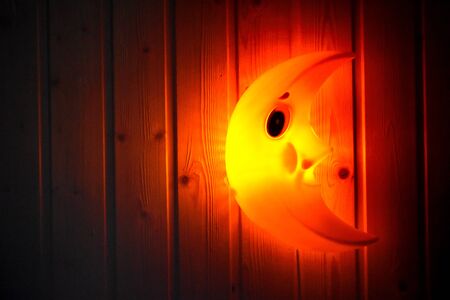 The lamp shines in the dark with a warm light. Sleeping with a flashlight.の写真素材