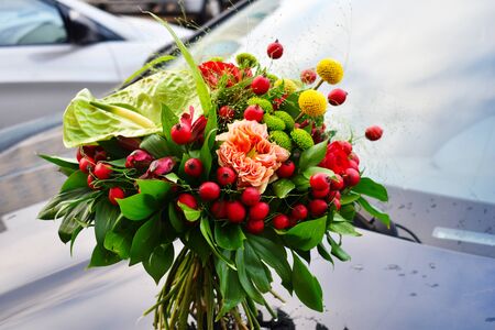 Spring flowers for the beloved. A blooming bouquet of flowers stands on the hood of a car. Original unusual wedding bouquet.の写真素材