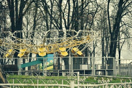 An abandoned street park with children's carousels. Autumn sad city landscape.の写真素材