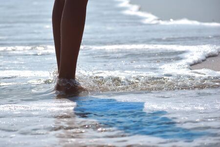 Feet along the line of the ocean. Sea vacation concept. Children's vacation at sea.