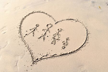 Men drawn in the sand. Happy Family on the beach. Family pattern of the sea. In vacation with children.の写真素材