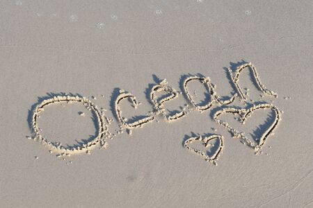 Summer memories. Drawings in the sand. Beach painted picture. Vacation in the tropics. Happy summer time at sea.の写真素材