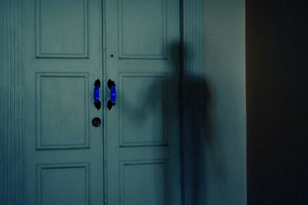 Ghost at the door. Hand holding a door handle. A mystical door into the unknown. The secret of the old door. The house is haunted.の写真素材