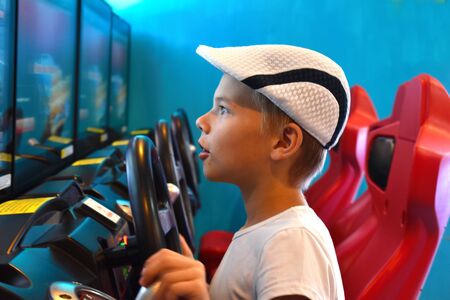 Racing car simulator. A little boy plays virtual games. Of computer racing.のeditorial素材