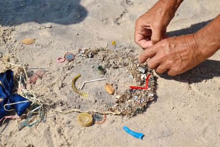 volunteers making figure. Colorful garbage on the sandy beach. Conservation of the ocean and the...