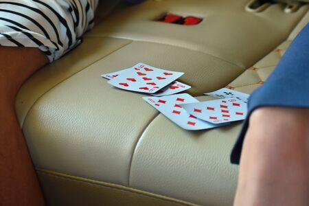 Two people play cards in the car. playing cards in the back seat of a car