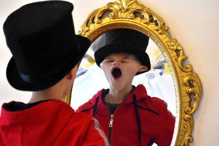 The child reflected in a distorting mirror. A fun reflection of the boy. Children's entertainmentの写真素材
