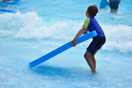 The boy in the pool in the summer autdoor. Holidays in the water Park. Joyful summer in the waterの写真素材