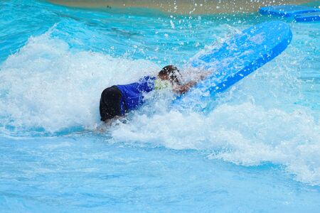 The boy in the pool in the summer autdoor. Holidays in the water Park. Joyful summer in the water