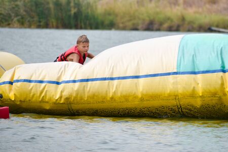 Boy child water inflatable slide. Sports water activities for kids.の写真素材