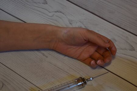 Overdose of heroin. Dead arm and a syringe. Suffering from drugsの写真素材