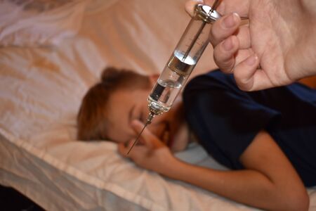 The boy and a large syringe. Medical vaccination. Anti-vaccine childrenの写真素材
