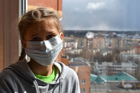 The girl sadly looking out the window. Stay in the house. Insulation home. virus infection.の写真素材
