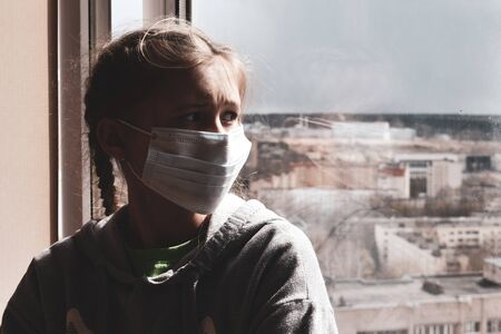 The girl sadly looking out the window. Stay in the house. Insulation home. virus infection.の写真素材